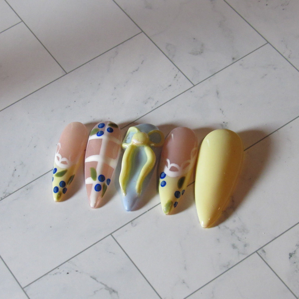 Colorful nail art designs on a marble floor