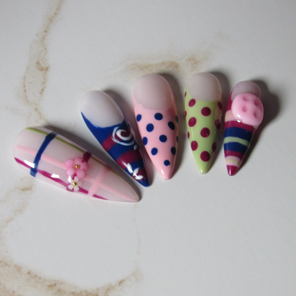 Set of colorful nail art designs on a marble surface